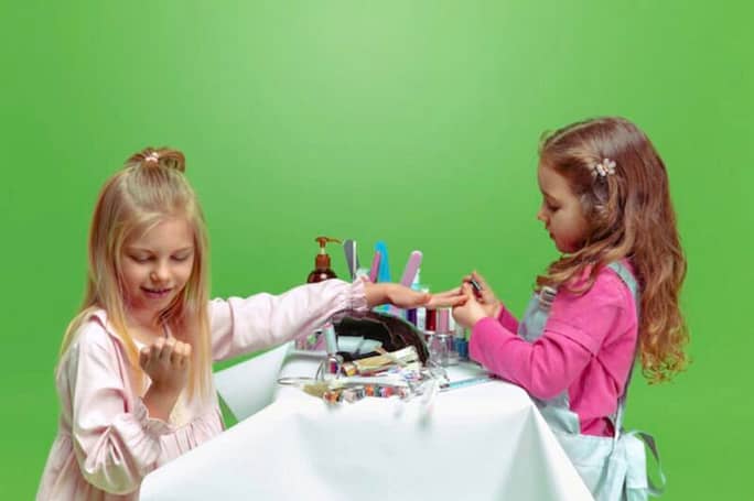 Kids applying nail polish on their nails