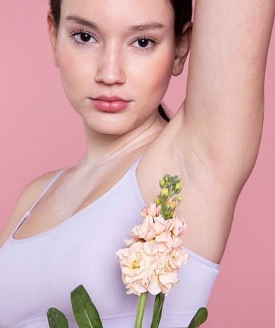 Woman holding a flower and showing her underarm