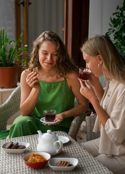 Two women enjoying their tea with cookies