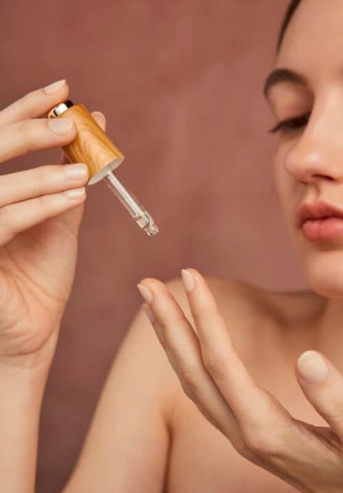 Woman putting on her plant-based oil in ger finger