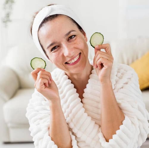 Woman holding out slices of cucumber