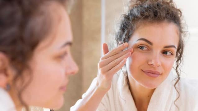 Woman inspecting her face