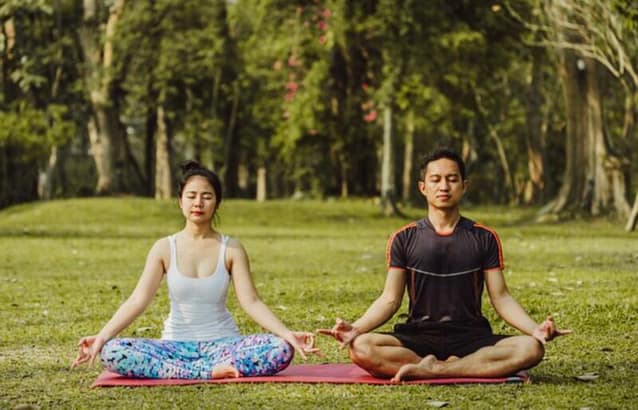 5144ADD4-9422-4899-A912-441170512DCB Couple doing their meditation in a park