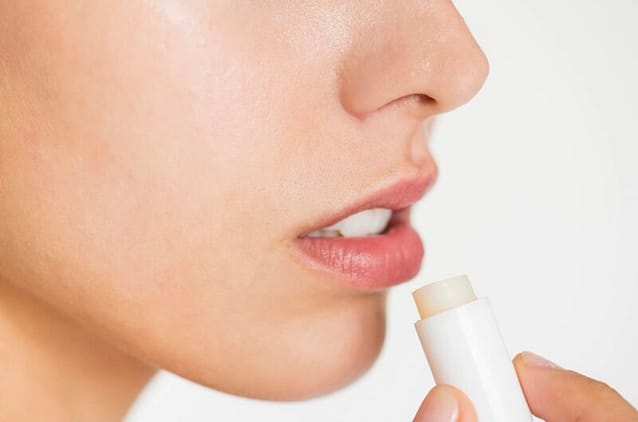 Woman applying natural lip balm
