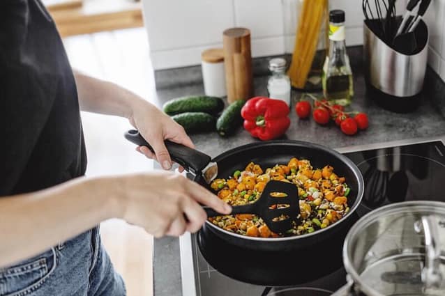 Woman cooking beans and vegetables