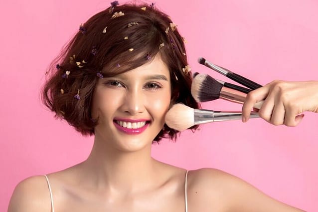954A8453-1CED-44D7-85CF-A4BCA0F01641 Smiling woman holding her cleaned make-up brushes
