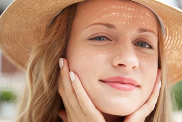 Woman wearing a hat as extra sun protection for her face