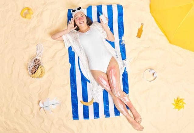 4109C5C6-CA4B-45F4-AED7-9EB1EF3F66CE Woman lying on the beach with sunscreen