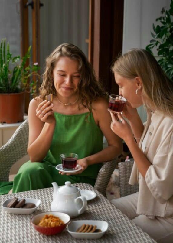 Two women enjoying their tea with cookies