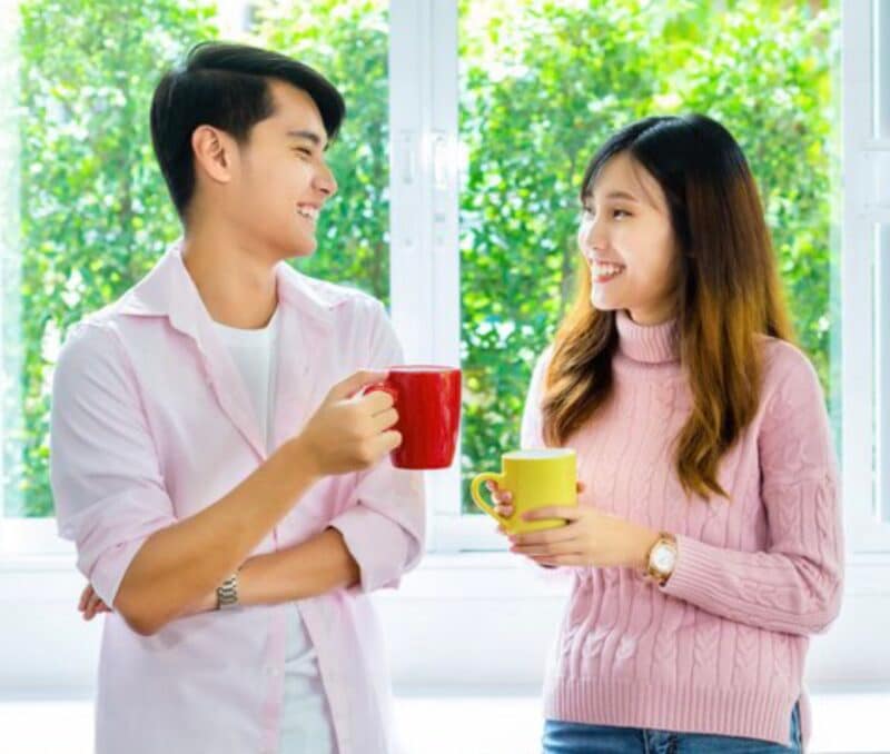 Couple smiling at each other while enjoying their lemongrass tea.