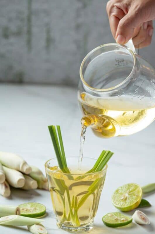 A pitcher of Lemongrass tea pouring on a glass