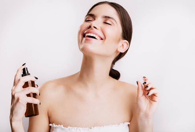 374DAD07-2EAB-449A-AEAF-24276B339043 Woman happily using her natural setting spray